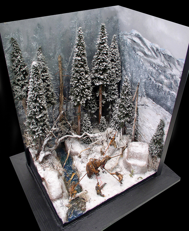 Diorama enneigé avec sapins, montagne et chasseur affrontant un ours près d'un ruisseau gelé