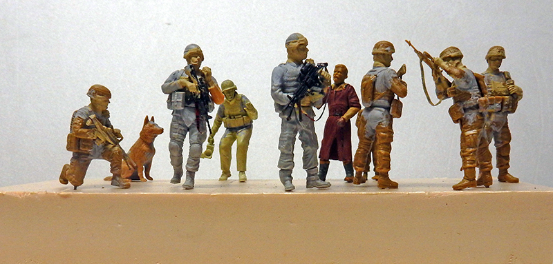 Figurines de soldats armés avec chien et civil à un check-point, peinture en cours