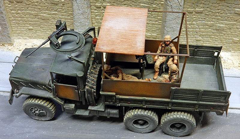 Maquette de camion militaire avec soldat et mitrailleuse à un check-point urbain