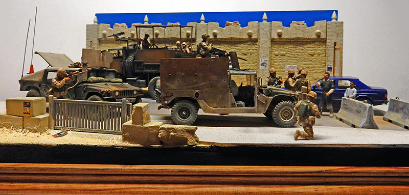 Diorama de checkpoint militaire en Irak avec véhicules blindés, soldats et figurines devant un mur fortifié