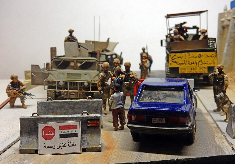 Diorama de checkpoint militaire en Irak avec soldats contrôlant une voiture bleue près d'un Humvee