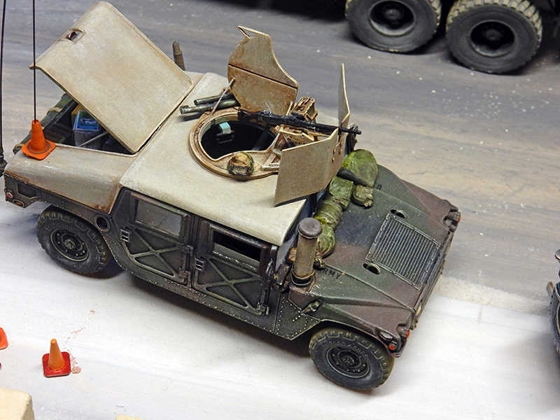 Maquette de Humvee militaire camouflé avec mitrailleuse de tourelle sur un diorama de checkpoint