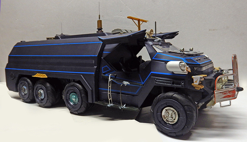 Maquette de véhicule blindé tout-terrain noir à six roues avec liserés bleus et antennes