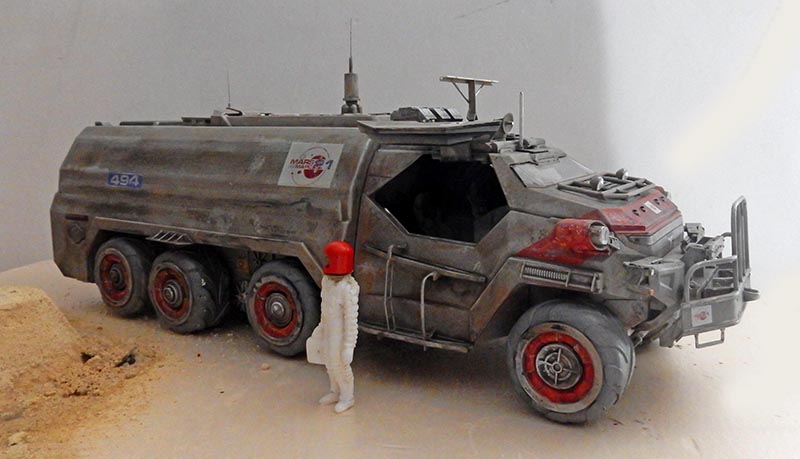 Maquette de camion-citerne tout-terrain à huit roues avec figurine d'astronaute en combinaison blanche