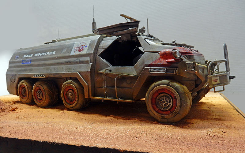 Maquette de véhicule blindé six roues Mars Industries patiné sur diorama de sol martien ocre