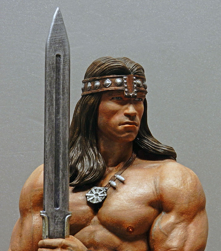 Buste peint de Conan le barbare musclé tenant une épée, bandeau et collier