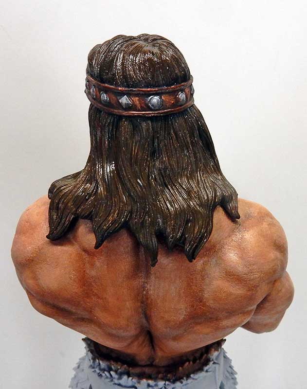 Vue de dos de la figurine Conan montrant chevelure, bandeau clouté et dos musclé peint