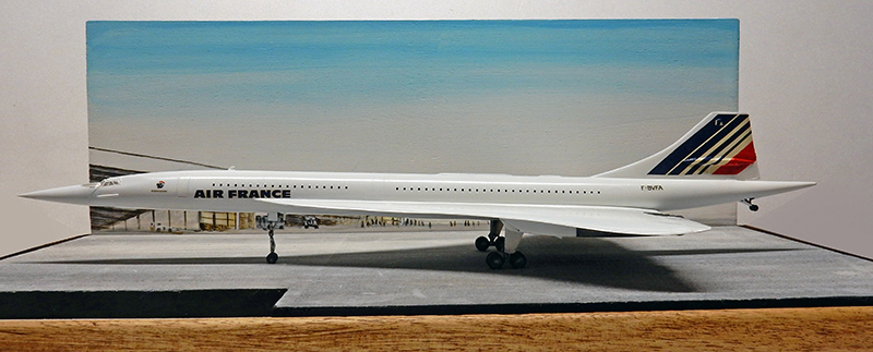 Maquette du Concorde Air France terminée, vue de profil sur socle avec décor d'aéroport