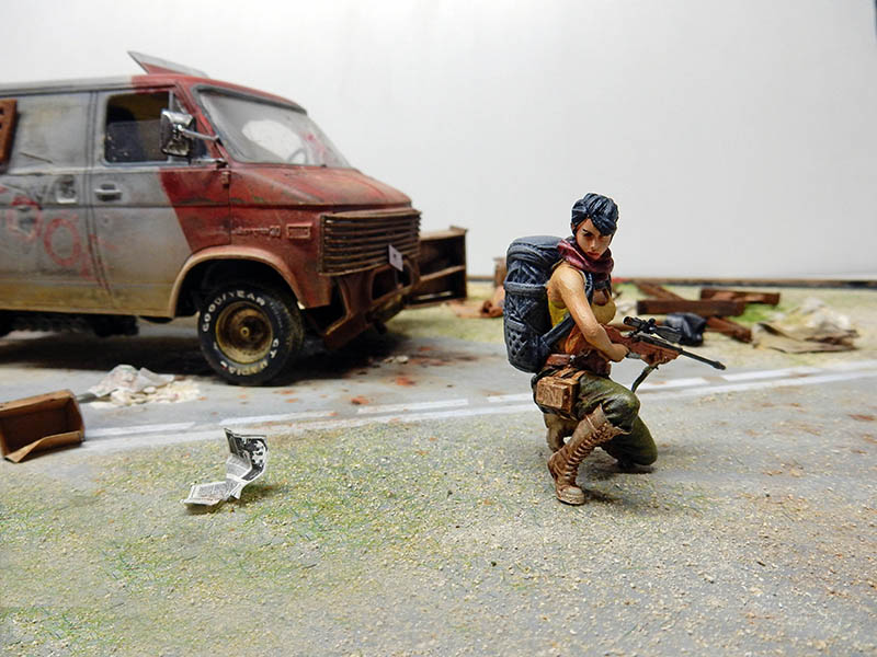 Diorama post-apocalyptique, survivante armée accroupie près d'un van rouillé abandonné