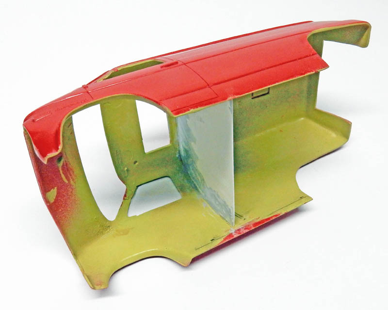 Carrosserie de maquette peinte en rouge avec apprêt vert et masquage intérieur
