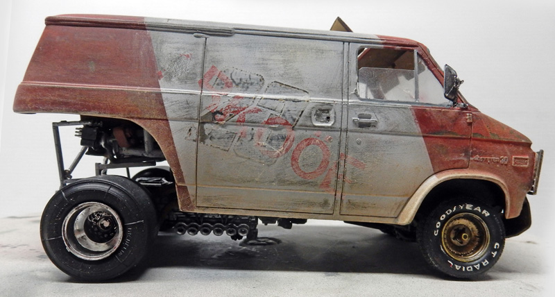 Maquette de fourgon vieilli vue de profil, carrosserie rouge et grise patinée avec graffitis et rouille