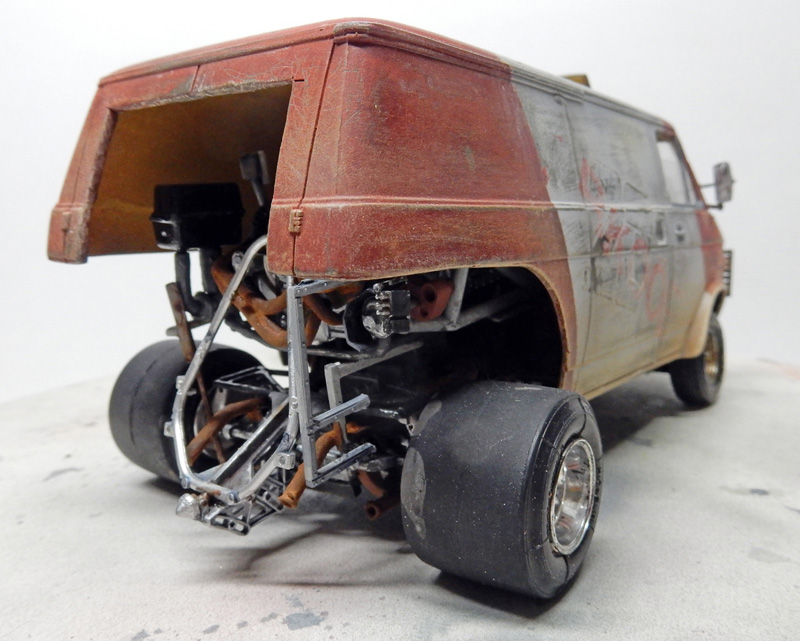 Maquette de van rouge vieilli avec châssis arrière apparent, moteur et larges pneus slicks