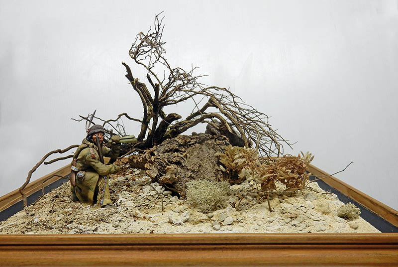 Diorama de maquettisme avec figurine de soldat près d'un arbre mort et terrain naturel rocailleux