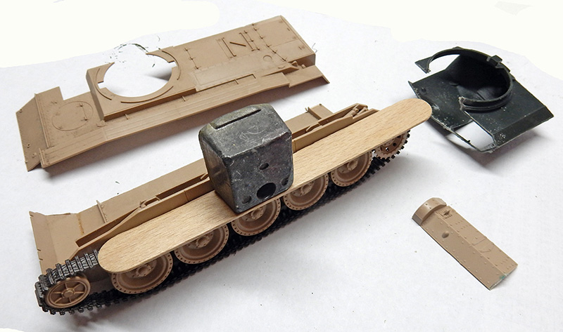 Pièces de maquette de char Crusader en cours d'assemblage avec poids de serrage