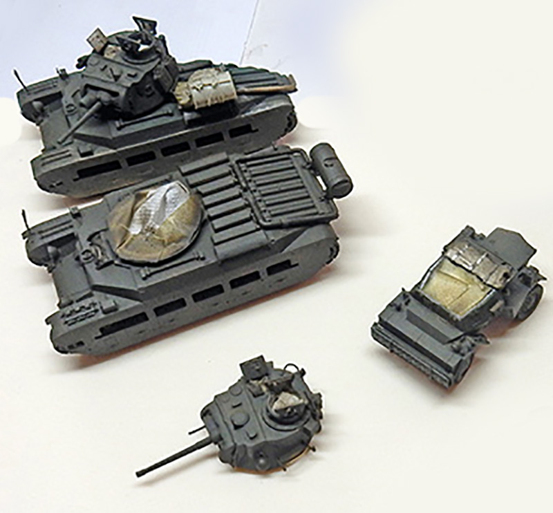 Maquettes de chars britanniques gris et véhicule blindé en cours de montage et peinture