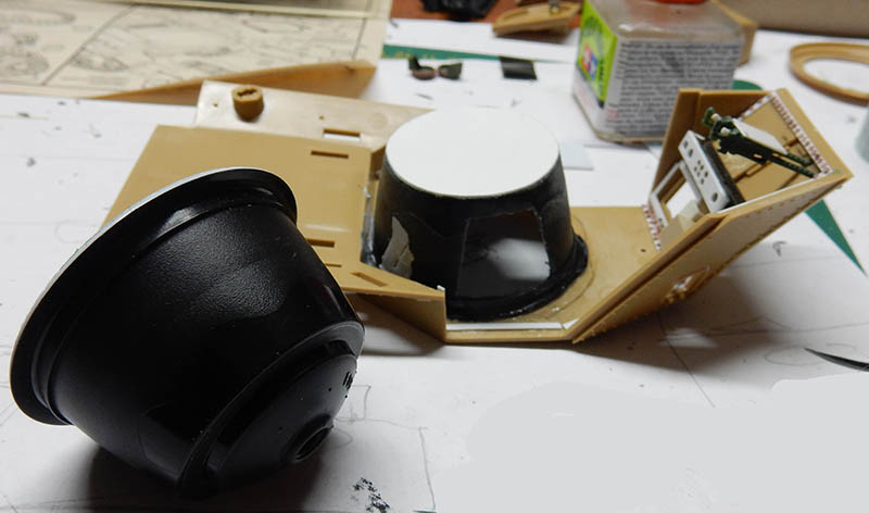 Pièces de maquette en cours d'assemblage avec tourelle peinte en noir sur l'établi