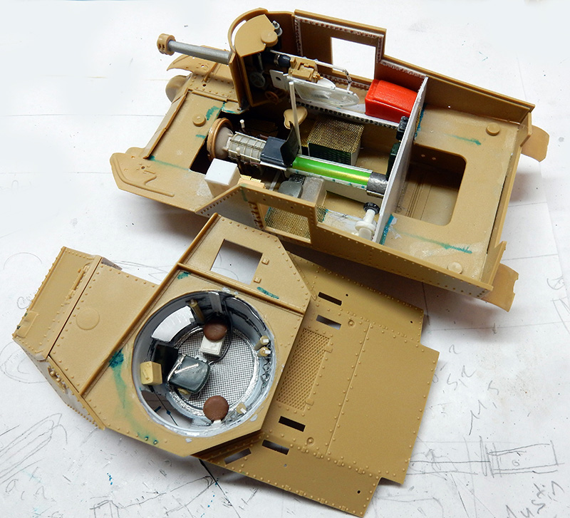 Maquette de char beige en construction montrant l'intérieur détaillé du canon, du moteur et de la tourelle