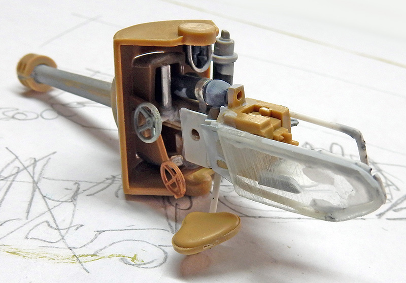 Maquette d'un canon antichar en cours d'assemblage avec affût, bouclier et siège posés sur un plan
