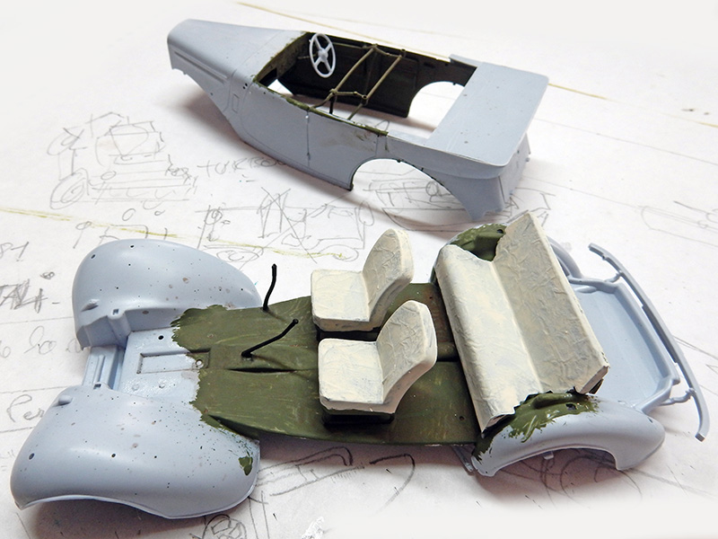 Pièces de maquette de véhicule militaire en cours d'assemblage avec sièges et carrosserie sur plan crayonné