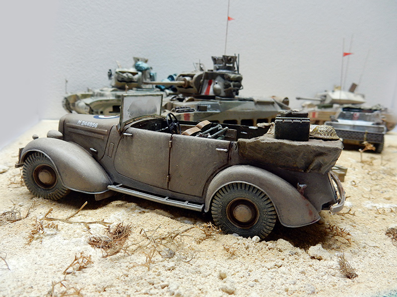 Maquette de voiture cabriolet militaire allemande sur diorama désertique avec chars en arrière-plan