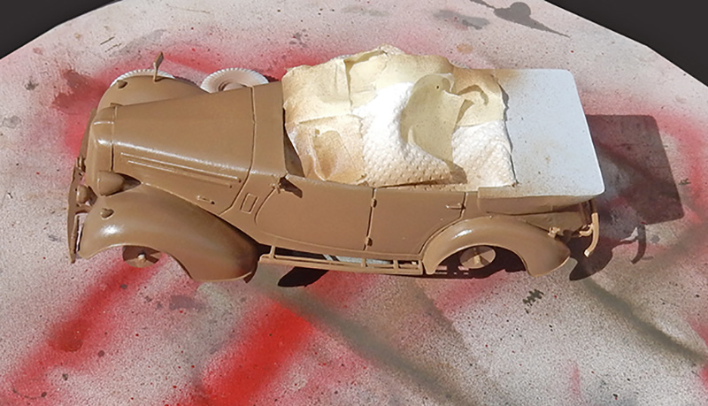 Maquette de voiture ancienne peinte en sable, masquée au papier avant peinture