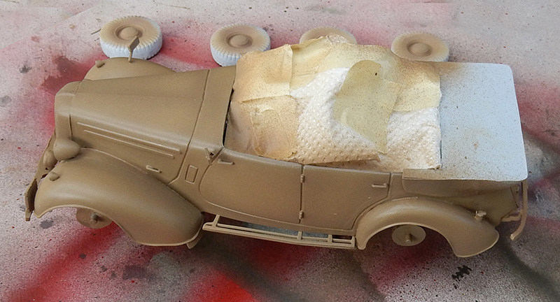 Maquette de voiture militaire peinte en sable, intérieur masqué, roues et carrosserie en cours de peinture