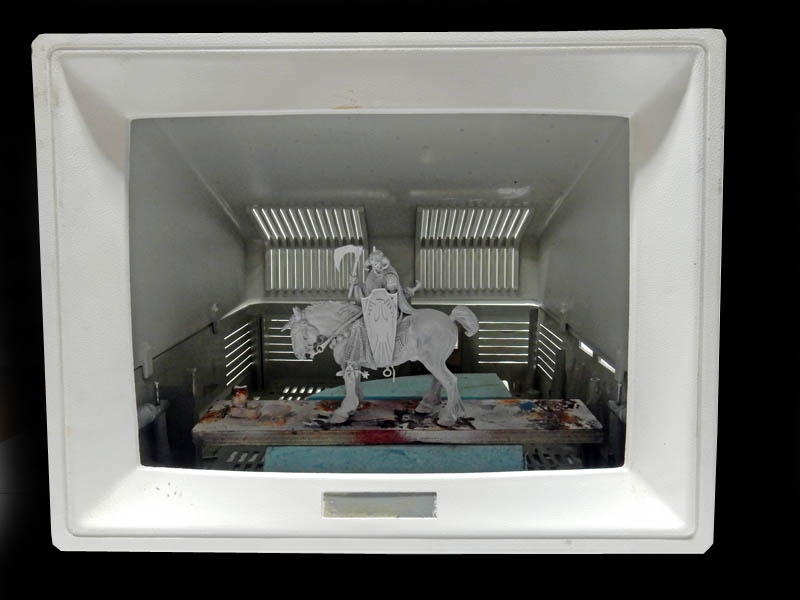 Figurine de cavalier en armure sur cheval gris placée dans une boîte à diorama blanche