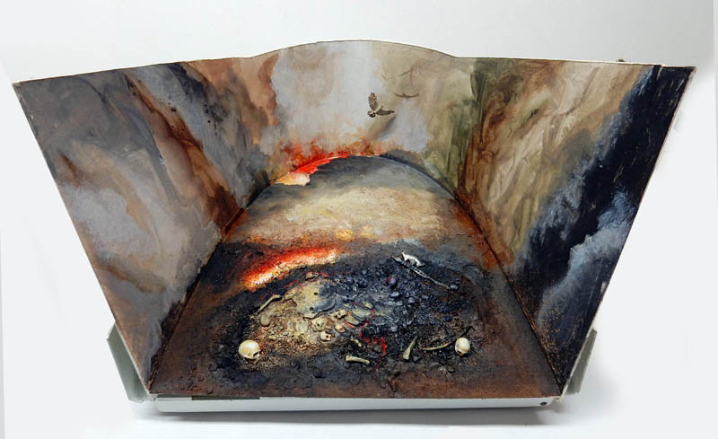 Boîte à diorama aux parois peintes formant un paysage volcanique sombre jonché d'ossements et de crânes