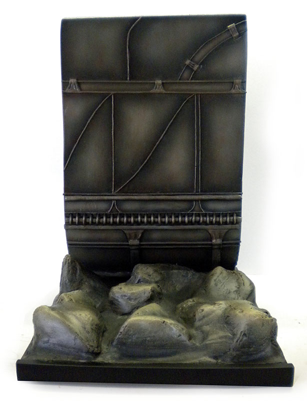 Maquette de décor avec mur en bois sombre et rochers gris à la base
