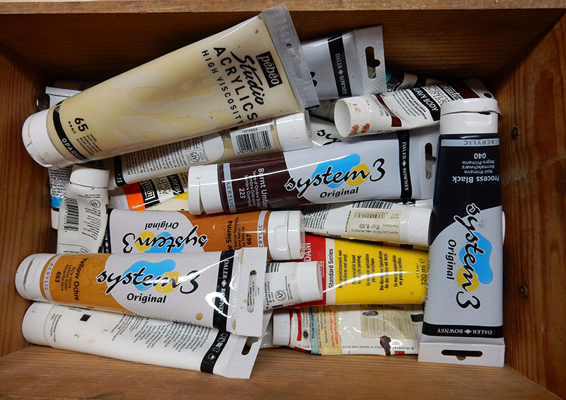 Tubes de peinture acrylique en vrac dans une caisse en bois, matériel de peinture