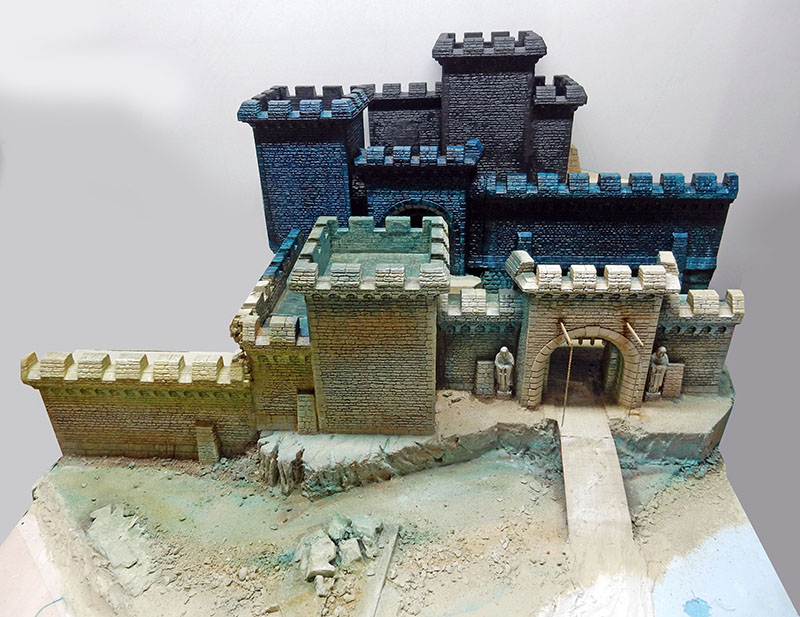 Château fortifié en cours de peinture, socle brut avec douves et gravats