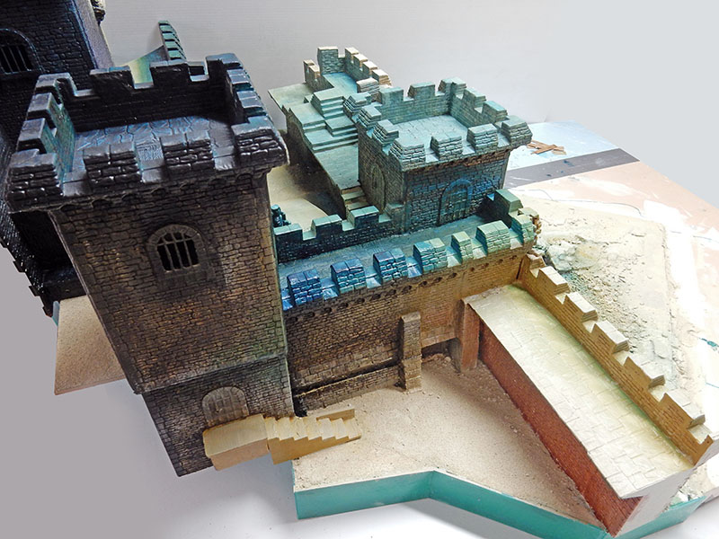 Maquette de château en construction, tours et remparts peints sur socle non terminé