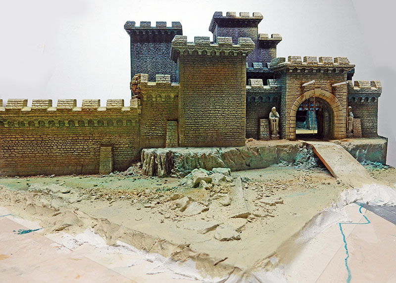 Maquette du château fortifié avec remparts peints, terrain sculpté en cours d'aménagement