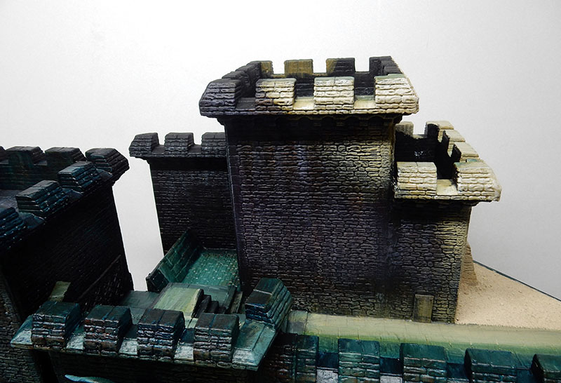 Murs de forteresse en pierre et tour crénelée peints, décor non encore terminé
