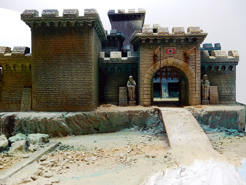 Diorama de l'entrée fortifiée du château, remparts crénelés, rampe d'accès et gravats