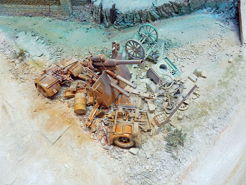 Amas de canons et pièces d'artillerie rouillés abandonnés sur terrain ravagé, diorama Die Burg 1945