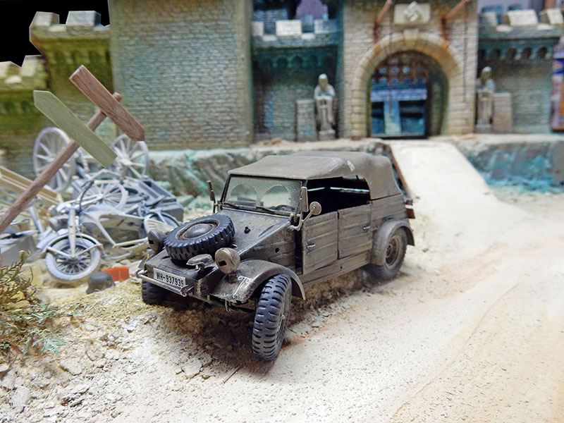 Kübelwagen poussiéreuse sur chemin de terre devant le porche du diorama Die Burg 1945