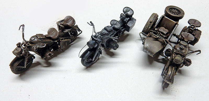 Trois maquettes de motos militaires allemandes peintes, dont une side-car, sur fond blanc
