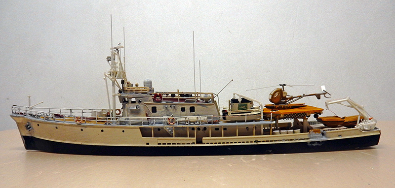 Maquette du navire Calypso de profil avec hélicoptère orange sur la plateforme arrière