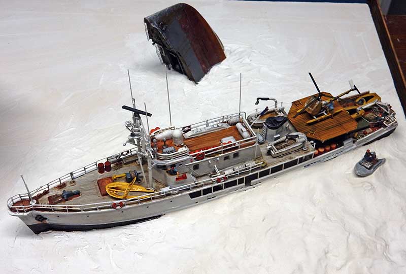 Maquette du navire La Calypso de Cousteau avec hélicoptère jaune sur une mer blanche