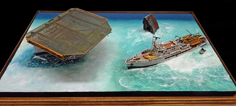 Diorama de la Calypso de Cousteau près d'une cage immergée sur une mer turquoise