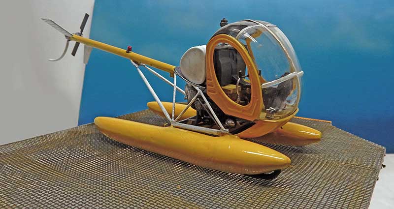 Maquette d'hélicoptère jaune à flotteurs et bulle transparente sur fond bleu