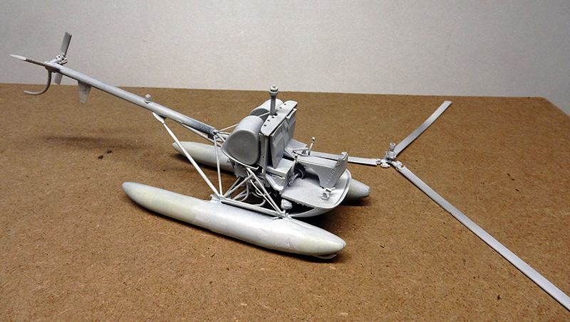 Maquette en cours de montage d'un hydravion à flotteurs et rotor, non peinte
