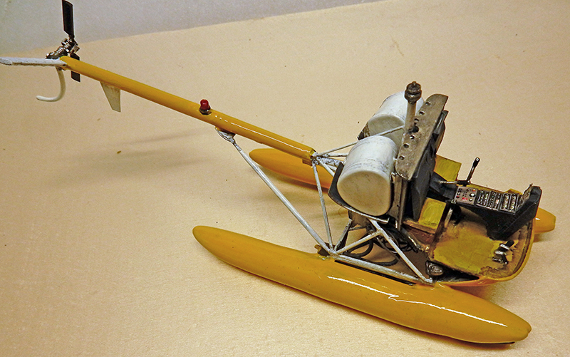 Maquette d'hélicoptère jaune à flotteurs en construction pour le diorama Cousteau