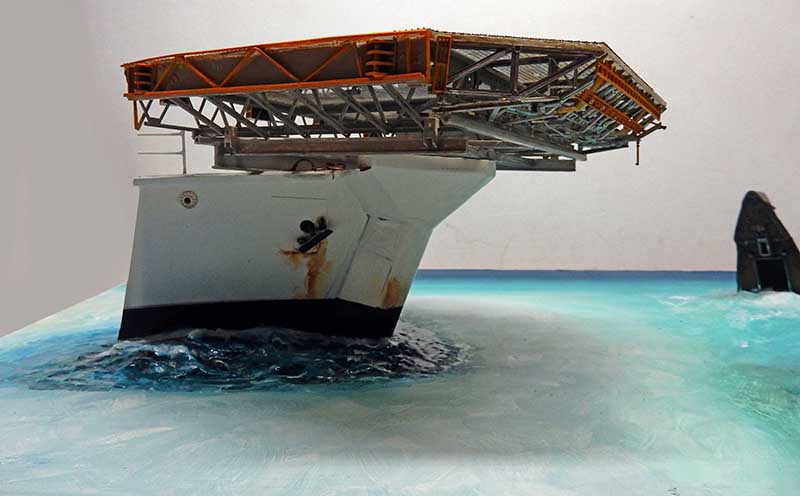 Maquette de la proue blanche de la Calypso s'enfonçant dans une mer turquoise