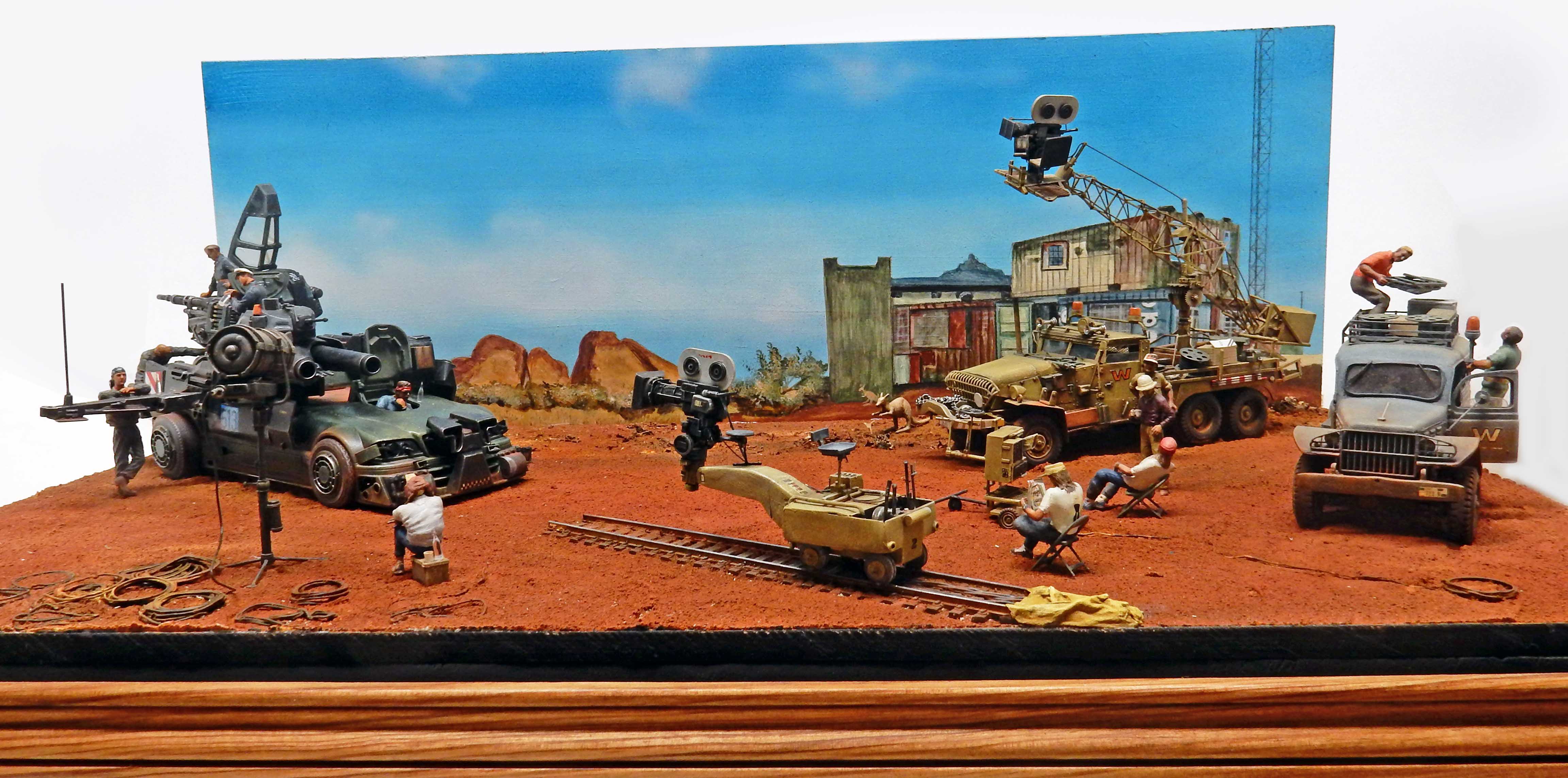 Diorama de tournage de film post-apocalyptique avec caméras, véhicules militaires et figurines dans un désert
