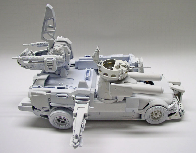 Maquette de véhicule blindé futuriste en cours de montage, pièces grises non peintes, tourelle et armes
