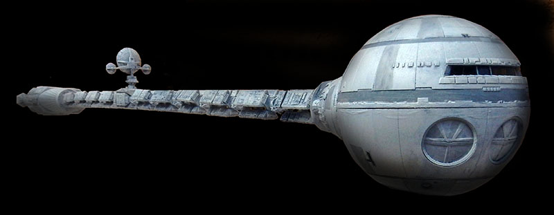 Maquette du vaisseau spatial Discovery One avec sa sphère avant et sa longue structure dorsale sur fond noir