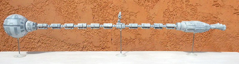 Maquette du vaisseau spatial Discovery One vue de profil sur fond orange