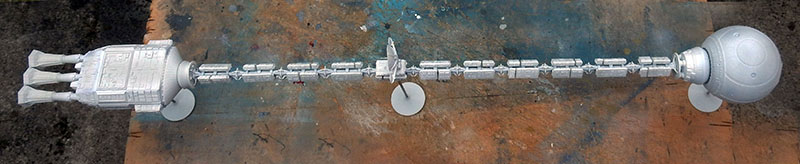 Maquette du vaisseau Discovery assemblée en cours de montage posée sur un établi